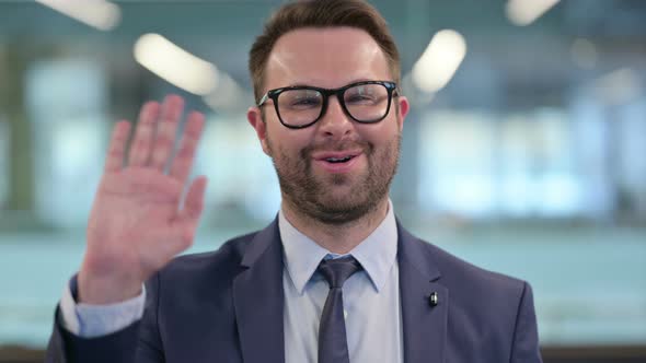 Portrait of Beautiful Middle Aged Businessman Waving Welcoming