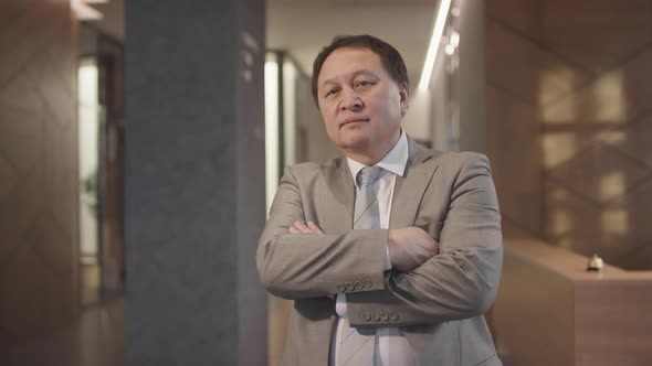 Asian Businessman Posing in Lobby of Hotel