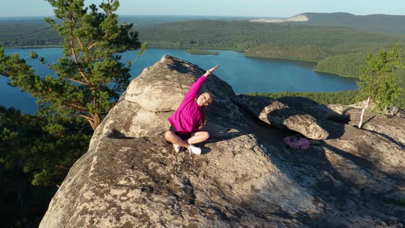 Aerial View of a Girl Doing Fitness and Yoga on a Rock