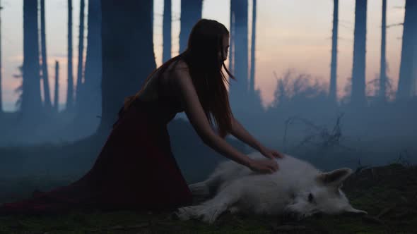 Woman kneeling and caressing a dog