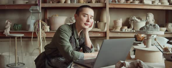 Portrait of Female Potter with Laptop in Workshop