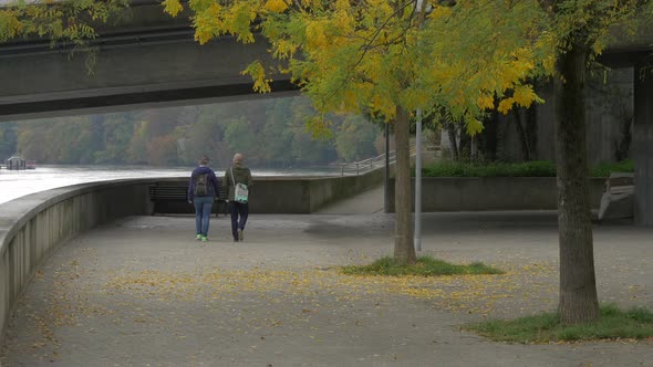 Two people walking on alley in a park