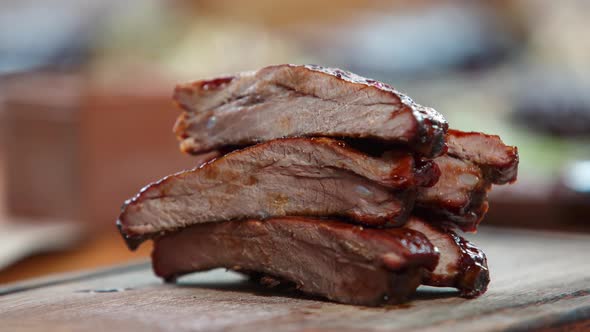 Pork ribs cooked for beer snack in sous-vide oven and served on wooden plate in bar