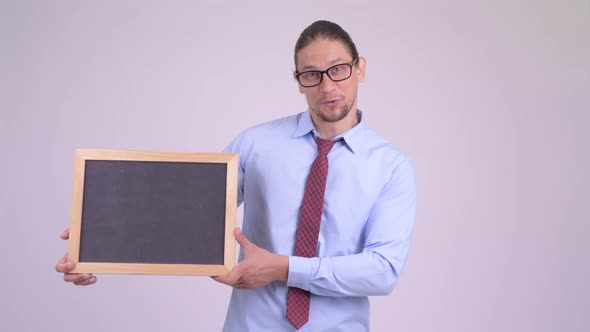 Happy Handsome Businessman Talking While Holding Blackboard