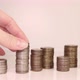 A woman's hand puts coins in a column. Investment concept. Metallic currency - VideoHive Item for Sale
