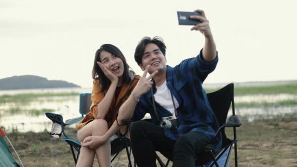 Young couple campers trekking in mountains park taking selfie on a sunny beautiful landscape nature.