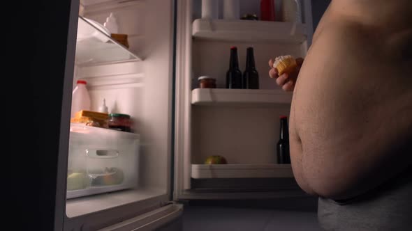 Lazy Obese Bachelor Eating Junk Food From Fridge and Drinking Beer, Calories