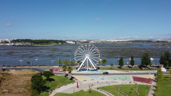 Aerial View Of Ferris Wheel, City Park And Estuary Seixal City On A Sunny Summer Day In Portugal. -