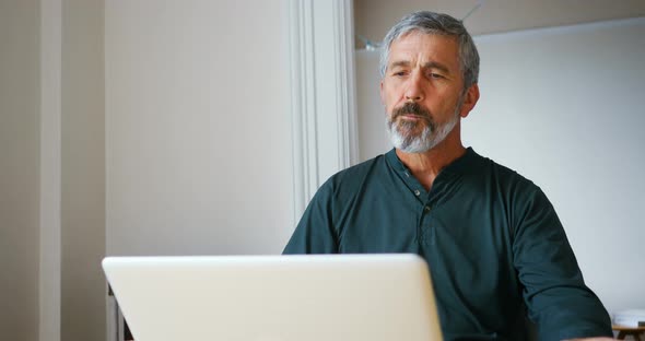 Man using laptop while having breakfast in living room 4k