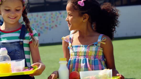 Smiling girl walking with a plate of breakfast