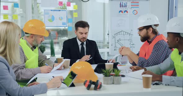 Chief Discussing with His Multiracial Subordinates-Builders or Architects the Details