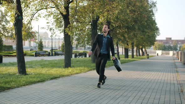 Ambitious Entrepreneur Walking in Urban Street Jumping Expressing Happiness