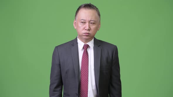 Mature Japanese Businessman Looking Tired and Bored