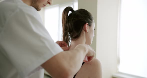 The Doctor is Treating a Woman with Suckers Cups on Her Back in a Clinic