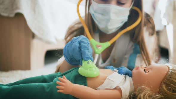 Beautiful Little Girl Playing Doctors with Doll at Home