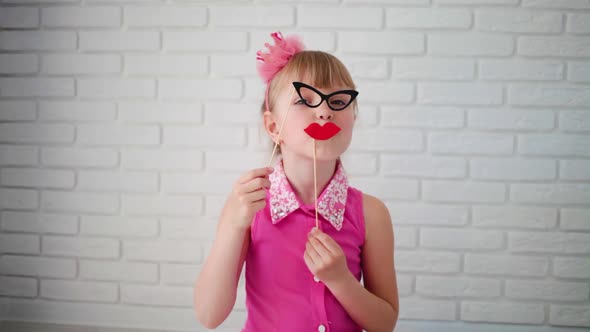 Close up portrait of fancy, funky small girl with fake  blow lips and glasses .