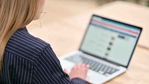 Rear View of Businesswoman Using Laptop 