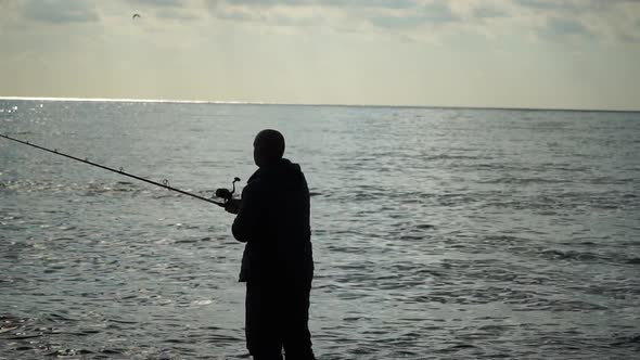 Man Hobby Fishing on Sea Tightens a Fishing Line Reel of Fish Summer