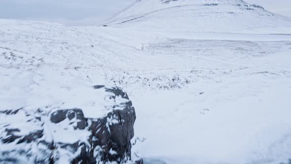 Drone Over Waterfall And Snowy Landscape Towards Kirkjufell