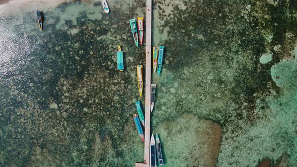 Aerial view of top down picture of colorful wooden boats. Boats at the pier and noise cloud