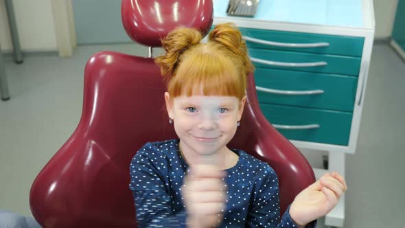 Pediatric Dentistry Concept. Charming Little Girl in Dental Chair. Lovely Red-haired Girl Having Fun