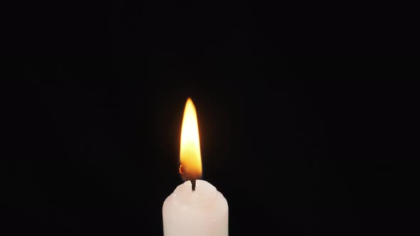 A Single Candle Is Lit on a Black Background. Lighting. Candle Flame