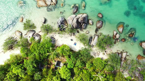 Beautiful unspoiled nature, Sandy beach surrounded by boulders in the azure tropical sea. Aerial