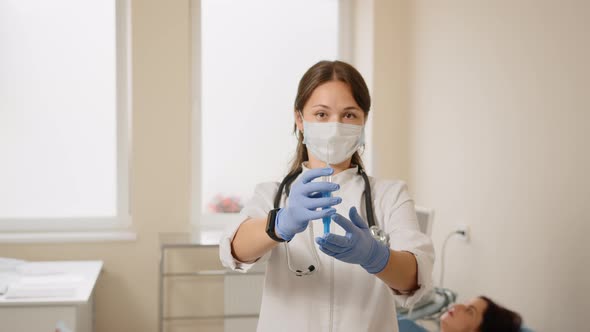 Doctor Standing Near Pregnant Woman with Syringe in Hands