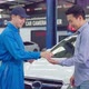 Asian automotive mechanic repairman handing car remote key to client. - VideoHive Item for Sale