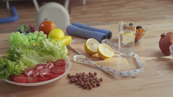 Concept of Proper Nutrition on the Table Are Dumbbells Measuring Tape Vegetables Fruits and Nuts