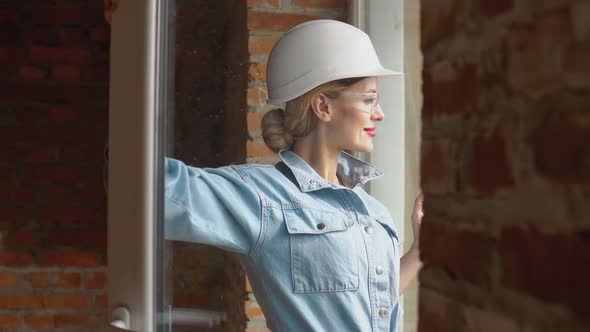 Female Architect Looking Out the Window at a Construction Site