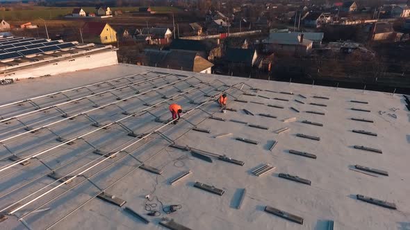 Workers on roof installing solar panels. 