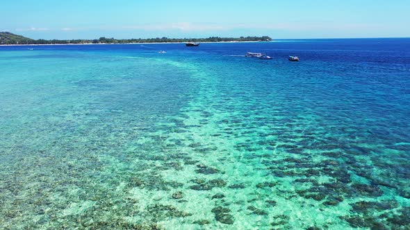 Beautiful healthy coral reef along the Thailand coast, Boats sailing in the sea with island on the h