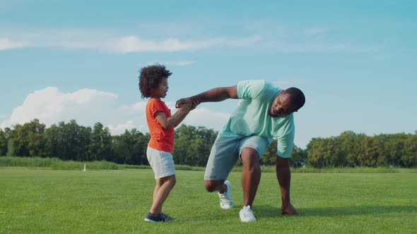 Little Child Helping Father To Stand Up Off Ground