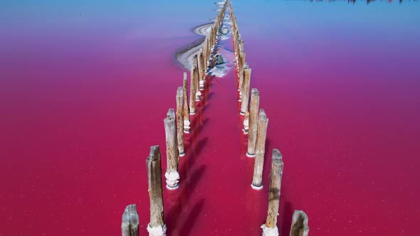 Epic Drone Flight Over Beautiful Pink Salt Lake with Deep Colorful Calm Water Surface and Small