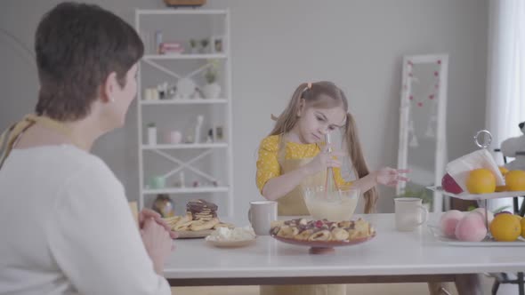 Cute Caucasian Girl Showing Thumbs Up and Smiling To Unrecognizable Grandmother. Pretty Child