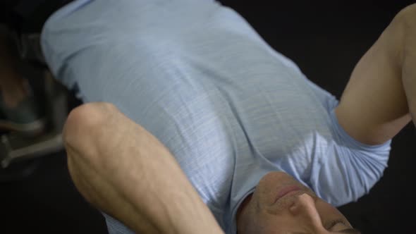 Close up image of man using barbell at the gym.