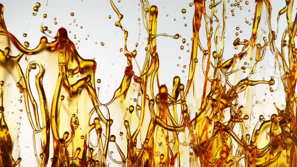 Super Slow Motion Shot of Splashing Golden Oil on White Background at 1000Fps alt