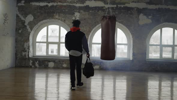 An Athlete Walking Into Room with a Bag Ready to Start Training