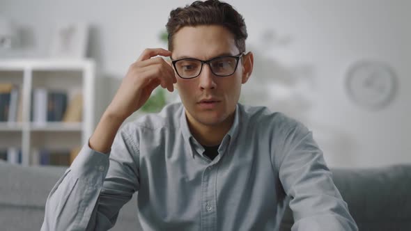 Tired Man Rubbing Eyes After Working on Laptop