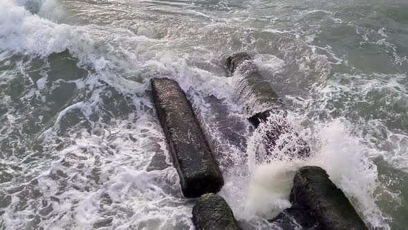 Wave Crashes in Slow Motion Onto Rocks with Foam and Water Flying in All Directions