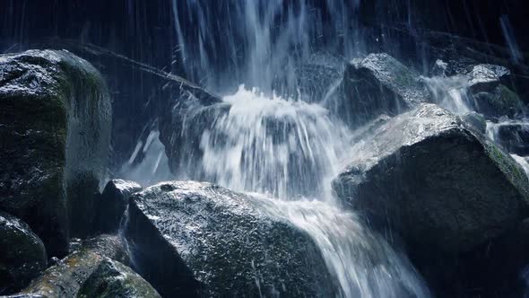 Moving Past Rocky Waterfall In The Mountains