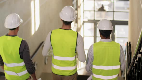 Architects in Helmets Walking Downstairs at Office