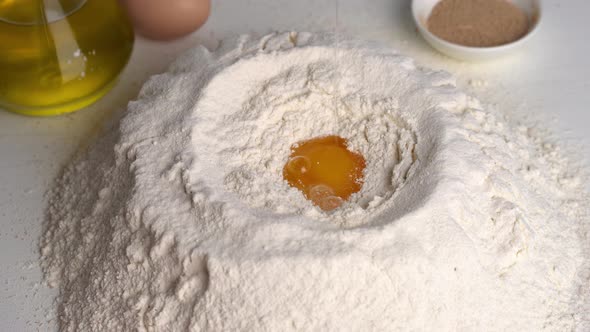 Baker Breaks Egg to Flour While Making Dough