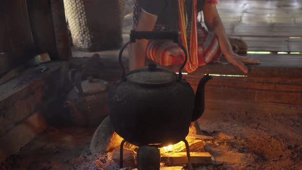 A portrait of karen tribe woman boiling water by using traditional kettle