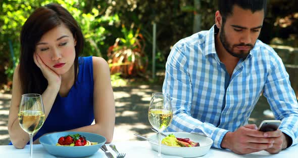 Couple ignoring each other in outdoor restaurant 4k