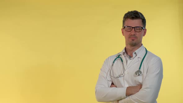 Handsome Doctor in Lab Coat Smiling To the Camera on Yellow Background