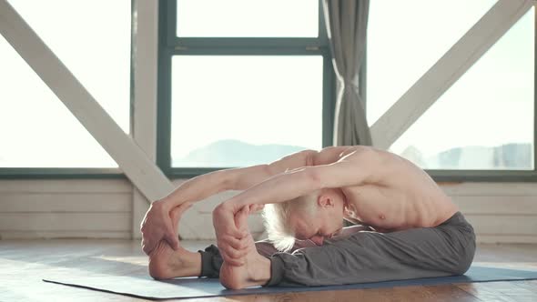 Mature Man Amongst Doing Power Yoga Exercises