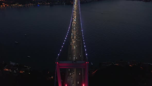 Beautiful Red Bridge Over Bosphorus in Red Light at Night with Car Traffic, Aerial Birds Eye View
