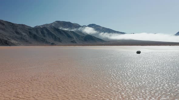 Drone Flying Around Black Rock on the Wet Cracked Surface of Death Valley Desert